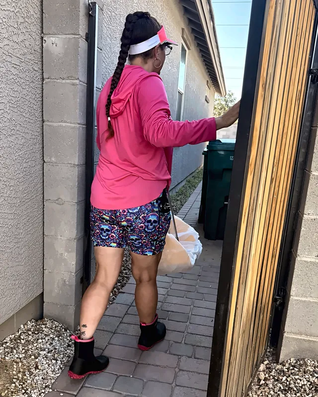 Britni walking into a backyard through the side gate